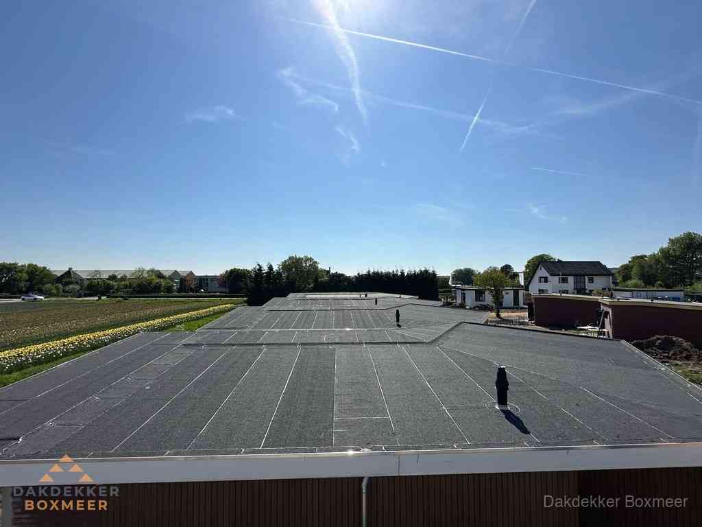 Groot plat dak met bitumen dakbedekking op bedrijfspand in Boxmeer Groot plat dak met bitumen dakbedekking op bedrijfspand in Boxmeer