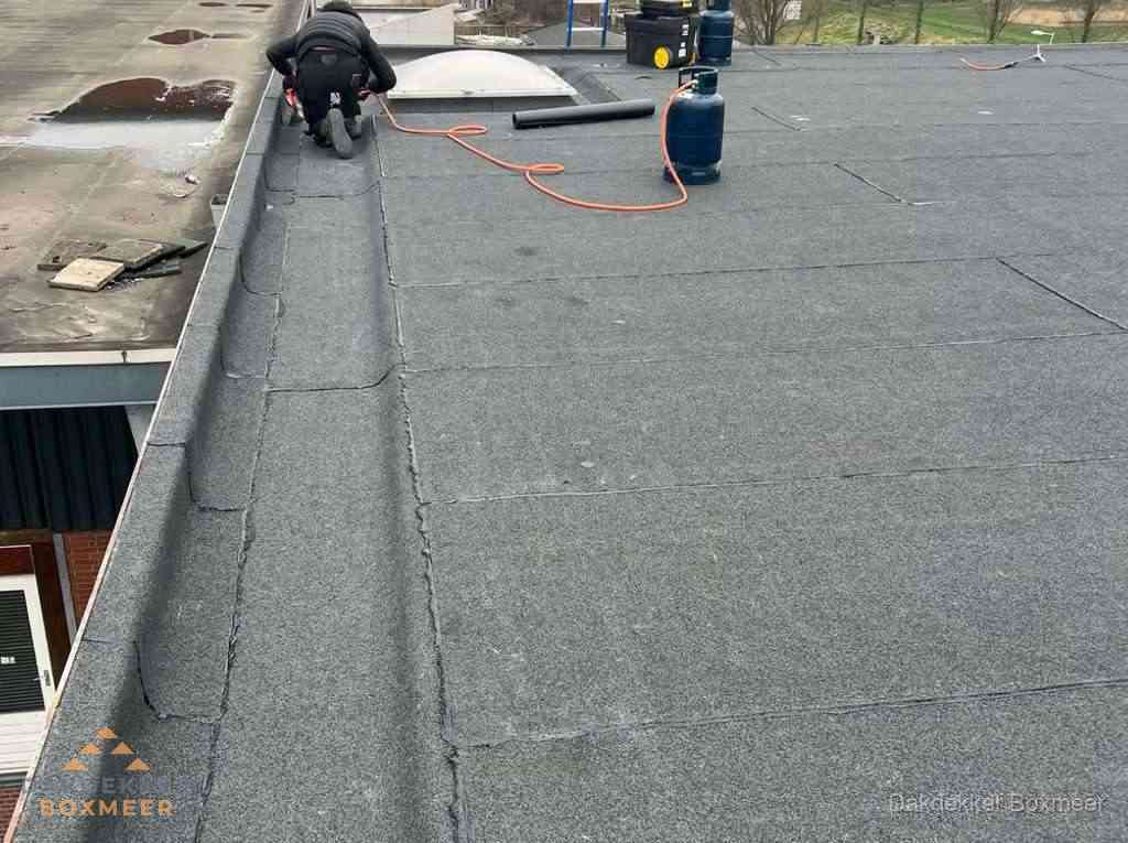 Dakdekker repareert bitumen dakbedekking op groot plat dak in Boxmeer Dakdekker repareert bitumen dakbedekking op groot plat dak in Boxmeer